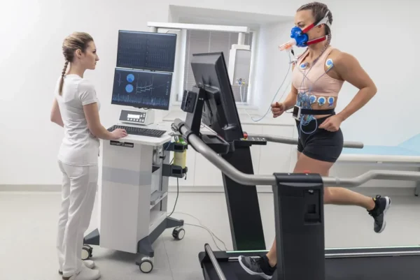 EKG tech helping out a male patient on tread mill