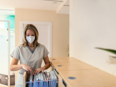 physiotherapist looks for file in filing cabinet